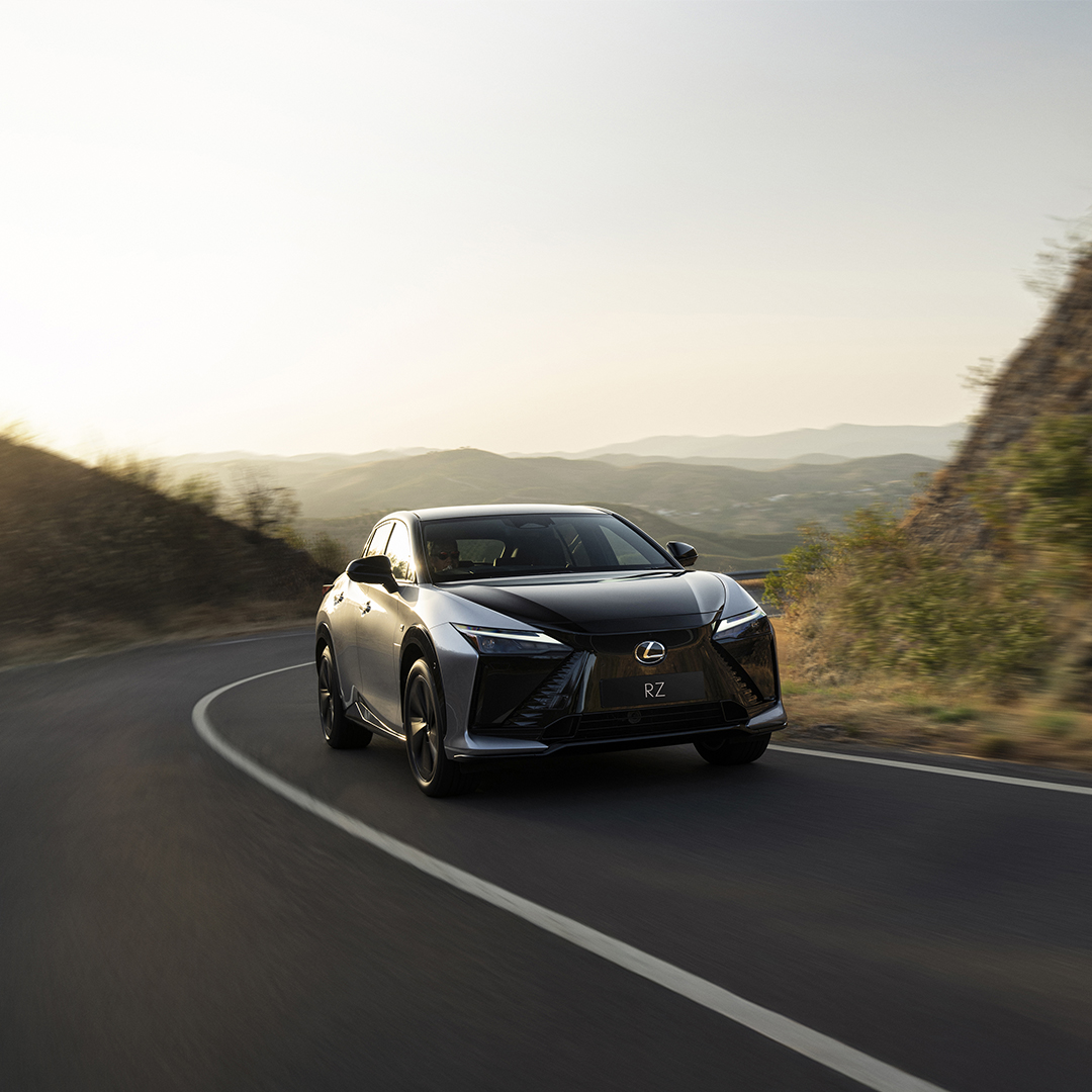A Lexus RZ drives along a winding road